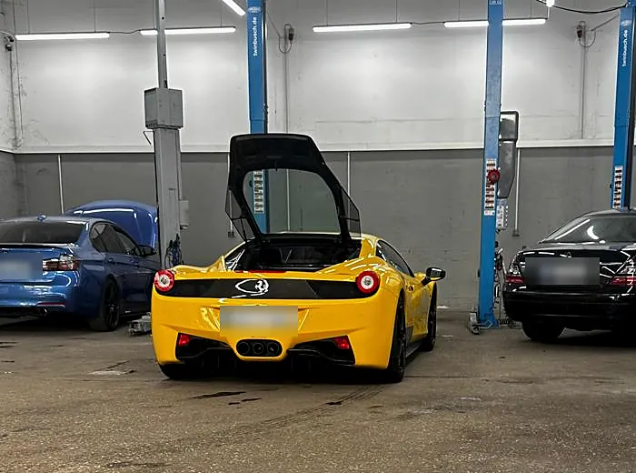 Ferrari in der Werkstatt - HZ Performance Gelber Ferrari 458 mit geöffneter Tür in der Werkstatthalle von HZ Performance